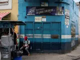 Varias personas a las puertas de una licorería cerrada en Venezuela.