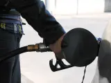 Un trabajador sirve gasolina a un vehículo.