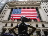 Fachada del New York Stock Exchange adornada con una bandera gigante de Estados Unidos.