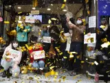 Loteros de la administración de "Doña Manolita" de Madrid festejan haber vendido décimos del premio gordo que ha recaído en el número 72.897, dotado con cuatro millones de euros por serie (400.000 euros por décimo).