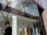 Una persona pasa por delante de un escaparate cerrado de Zara durante el confinamiento.