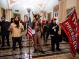 Varios asaltantes al congreso llegan a las puertas de la cámara ataviados con atuendos de nativos americanos.