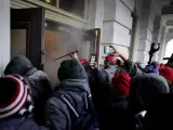 Seguidores de Donald Trump son repelidos con gas lacrimógeno mientras intentan entrar en el Capotolio.