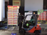 Un operario descargar un camión con frutas en los hangares de Mercamadrid que trata de recuperar la actividad.