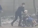 Una anciana es evacuada de la residencia afectada por la explosión.