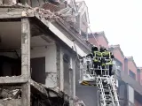 Dos bomberos trabajan en un inmueble momentos posteriores a una fuerte explosión registrada la calle Toledo