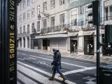 Una mujer pasea en una calle vacía de Portugal.