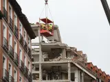 Operarios colgados de una grúa trabajan en la inspección del edificio tras la explosión.
