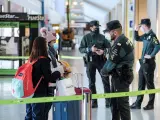 Miembros de la Guardia Civil y la seguridad privada hacen controles a los pasajeros en el aeropuerto de Ibiza este sábado, tras el cierre de la isla de Ibiza de forma perimetral.