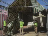 Operarios trabajan en el desmontaje de un toldo en una de las casetas de las instalaciones de la Feria de Abril de 2020