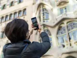 Una turista realiza una fotograf&iacute;a con su tel&eacute;fono m&oacute;vil a la Casa Batll&oacute; de Barcelona