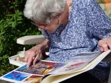 Una anciana observa un álbum de fotos, en una imagen de archivo.