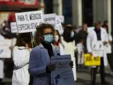 Una trabajadora sanitaria sostiene un cartel durante una concentración convocada por la Asociación de Médicos y Titulados Superiores de Madrid (AMYTS), en la Puerta del Sol.