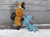 Según un portavoz del servicio meteorológico Fobos, en Moscú han caído 56 centímetros de nieve. "La última vez que había caído tanta nieve en la capital fue en marzo de 2013", ha asegurado. En la imagen, una mujer trata de atravesar la calle con un carrito de bebé.