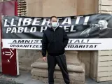 El rapero Pablo Hasel delante de una pancarta que pide su libertad, en Lleida el 10 de febrero de 2021.