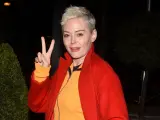 La actriz Rose McGowan haciendo el símbolo de la paz y la victoria con los dedos.