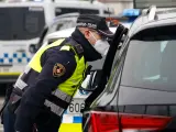 Un agente de la Guardia Urbana habla con un conductor en un control en la Ronda Litoral de Barcelona.