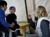 Una supervisora juega con dos niños en la sala de espera de la clínica de Médicos Sin Fronteras en un campo de refugiados en Lesbos.