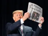 El expresidente de Estados Unidos, Donald Trump, sostiene un periódico en un acto público.