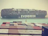 Unos de los cargueros más grandes del mundo ha quedado encallado y atravesado en el Canal de Suez en la mañana de este martes y ha bloqueado el tránsito por este fundamental paso marítimo egipcio, según informa 20minutos. El MV Ever Given está considerado como uno de los buques portacontenedores más grandes del mundo y transportaba mercancías entre Asia y Europa. ​ ​Según Evergreen Marine Corp, la naviera taiwanesa que gestiona este navío de bandera panameña, el navío se había visto golpeado por fuertes vientos en su entrada al canal, que lo habían llevado a encallar, aunque ninguno de sus contenedores había caído al agua. ​ ​Según las primeras informaciones no se habrían producido daños personales entre la tripulación, ni contaminación alguna en el canal, a pesar de que la proa del barco está en contacto con el muro occidental del Canal. Las autoridades egipcias han enviado varios barcos de arrastre para tratar de empujar la nave en el sentido correcto y reabrir el tráfico. ​ ​De momento el tráfico naval en esta fundamental arteria mundial está detenido hasta que este gigantesco buque pueda retomar su camino. El Ever Given ha quedado varado a unos 6 kilómetros al norte del acceso sur del canal, cerca de la ciudad de Suez, una zona del canal que es de vía única. El barco viajaba con destino final a Rotterdam, Holanda, antes de quedar atascado. Según informa la agencia Bloomberg, más de cien navíos estarían esperando ya la solución del incidente. Por el canal de Suez se calcula que circula el 10% del comercio mundial.