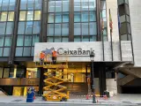 Operarios colocan el logo de CaixaBank en el edificio que albergaba la sede de Bankia en València