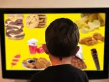 Imagen de archivo de un niño contemplando un menú de productos no saludables.