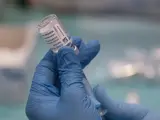 Una profesional sanitaria sostiene una jeringuilla con un vial de la vacuna contra la COVID-19 de AstraZeneca en un dispositivo de vacunación en el pabellón SADUS en Sevilla (Andalucía, España), a 24 de marzo de 2021