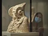 Archivo - Una persona protegida con mascarilla observa la escultura de La Dama de Elche disponible en el Museo Arqueológico en Madrid