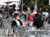 Varios clientes conversan en la terraza de un bar en el madrileño barrio de Aluche.