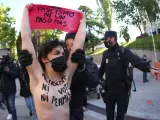 Una activista de Femen, que protestaba delante del colegio San Agustín en Madrid, donde ha votado Rocío Monasterio (VOX), es interceptada por agentes de policía.