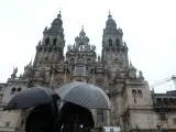 Una pareja observa la catedral de Santiago sin andamios despu&eacute;s de varios a&ntilde;os de obras.