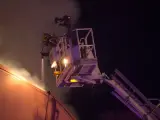 Los bomberos continúan los trabajos de extinción del incendio que afecta a una nave de embutidos en Vilalba (Lugo)