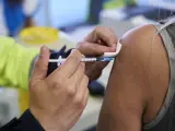 Un sanitario vacuna a una mujer con la vacuna de Pfizer en el Wanda Metropolitano, en Madrid.