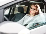 Una mujer llegando tarde al trabajo por el tráfico.