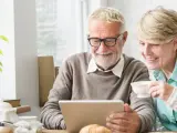 Dos pensionistas miran el ordenador.