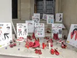 Diversos parells de sabata de color roig, vés-les i cartells contra la violència contra les dones a les portes de la Subdelegació del Govern a Alacant, on hui s'ha guardat un minut de silenci en repulsa de l'assassina