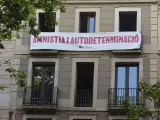Òmnium despliega una pancarta ante el Liceu para pedir a Sánchez amnistía y autodeterminación, en lugar de los idultos.