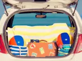 Maletas, toallas y pelotas de playa en el maletero del coche.