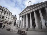Un hombre camina frente a el Banco de Inglaterra y la Royal Exchange en Londres.