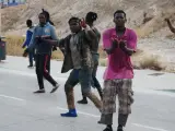 Varios inmigrantes subsaharianos celebran en Melilla tras conseguir saltar la valla fronteriza este jueves.