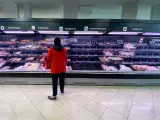 Una mujer observa los alimentos que quedan en los refrigeradores de carne de un supermercado un día marcado por colas de gente deseosas de hacer acopio de alimentos y otros productos debido al avance del coronavirus en España, en Madrid (España), a 10 de marzo de 2020. 10 MARZO 2020;SUPERMERCADO;MERCADONA;CORONAVIRUS;VIRUS Eduardo Parra / Europa Press (Foto de ARCHIVO) 10/3/2020