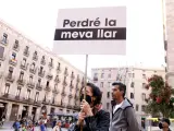 Una mujer exhibe una pancarta con el mensaje: "Perderé mi casa" en la protesta a favor de los hogares compartidos en Barcelona.