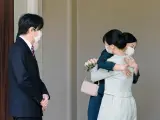La princesa Mako de Japón (a la derecha) abraza a su hermana, la princesa Kako, en presencia de su padre, el príncipe Akishino, al salir de su residencia para contraer matrimonio con Kei Komuro, en Tokio.
