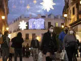 Varias personas cargan con bolsas durante las fiestas de Navidad.