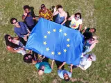 Un grupo de jóvenes sostiene la bandera europea.