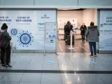 Un grupo de viajeros hacen cola para realizarse test de coronavirus en un centro instalado en el aeropuerto de Múnich, Alemania.
