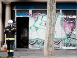 Un bombero habla por teléfono junto al local que se ha quemado en Barcelona y en el que han muerto cuatro personas.