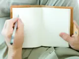 Una persona zurda escribiendo con la mano izquierda.