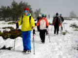 Grupo de excursionistas con raquetas en compañía de un guía, la mejor manera de disfrutar de la montaña en invierno.