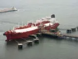 Barco metanero descargando gas en un puerto.